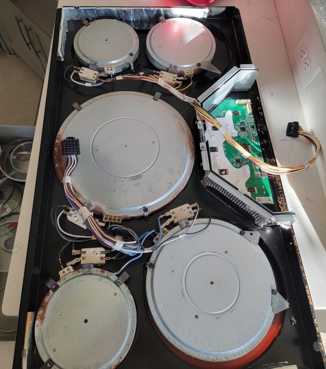 A stove top with a lot of wires coming out of it