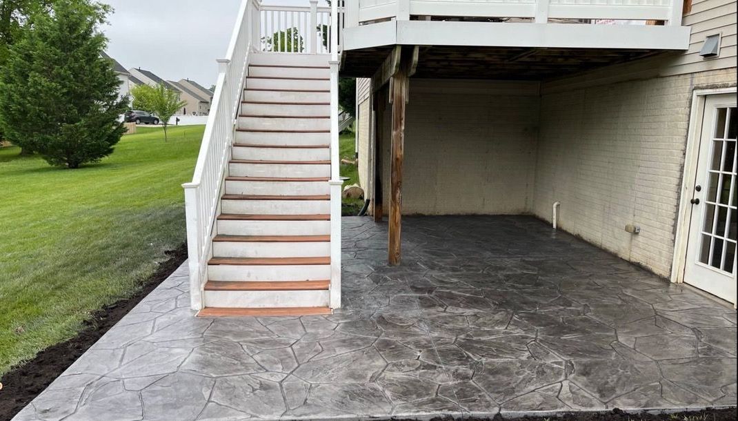 Custom stamped concrete patio at base of deck stairs in Frederick MD