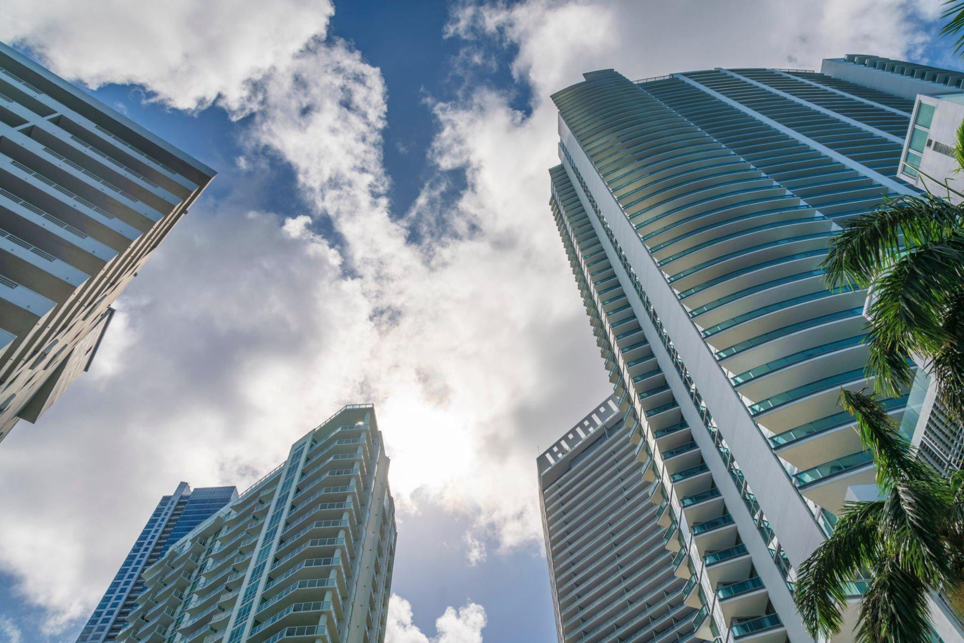 low angle view of condominium buildings with clouds covering the sky above at miami