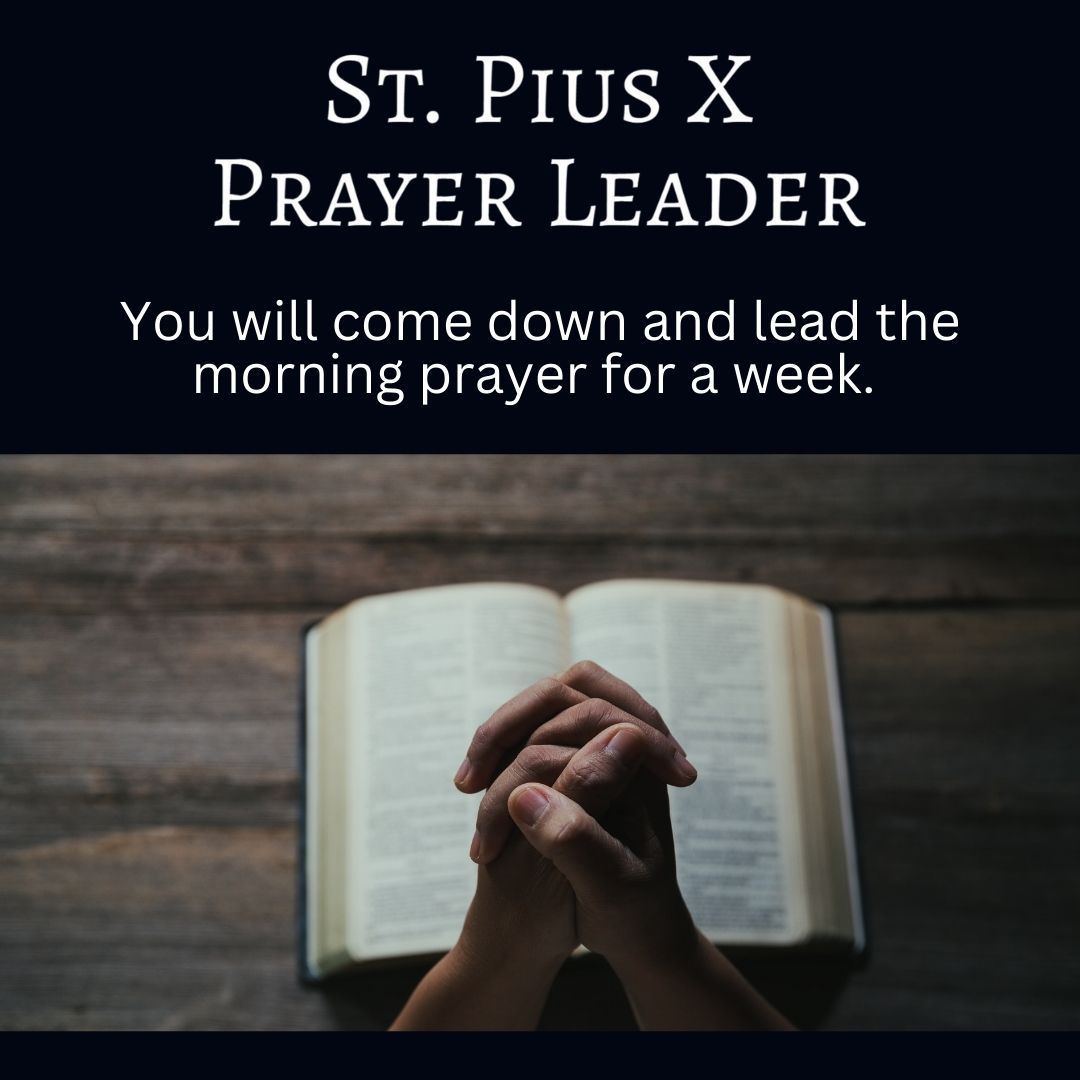 A person is praying with their hands folded in front of an open bible