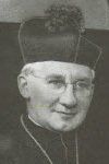 A black and white photo of a man wearing a hat and glasses.