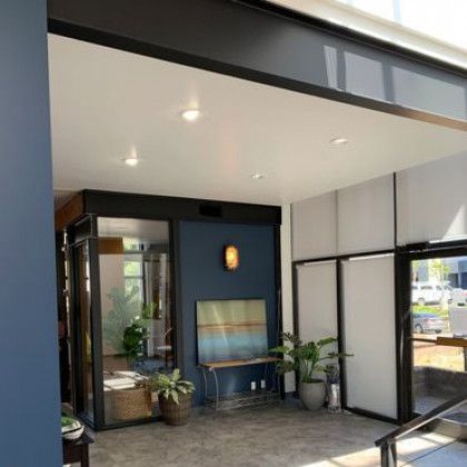 A room with a painting on the wall and plants in pots.