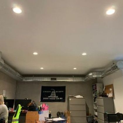 A room with a ceiling fan and a sign on the wall.