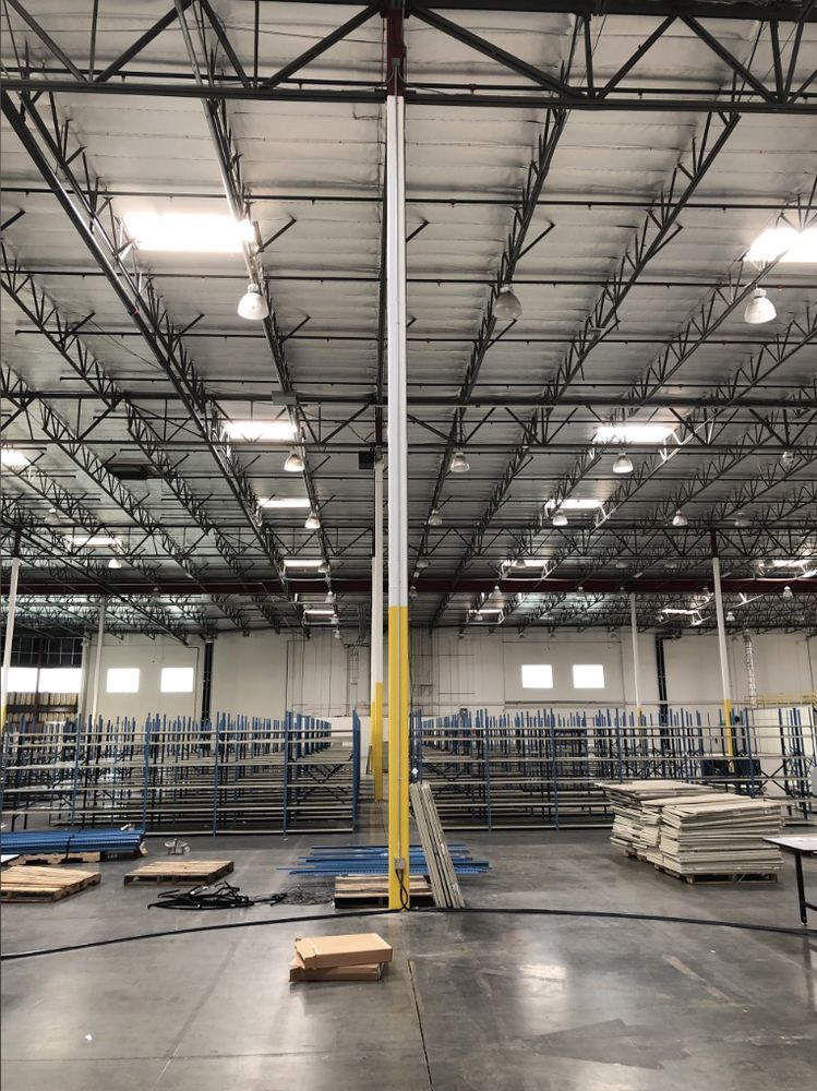 A large warehouse with lots of shelves and a ladder