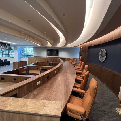 A large conference room with a long wooden table and chairs.