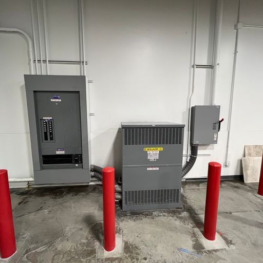 A room with a lot of electrical equipment and red poles.