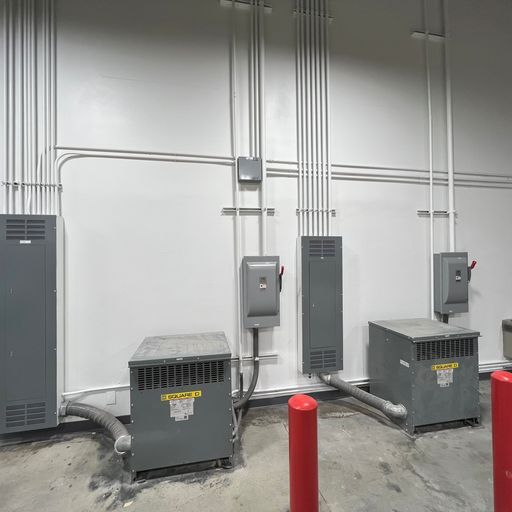 A row of electrical equipment is sitting in a room next to a wall.