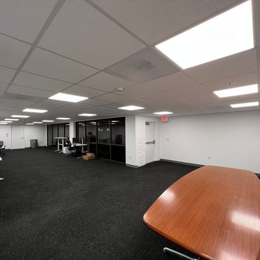 A large empty room with a wooden table in the middle of it.