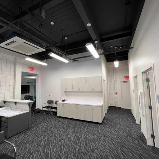 A large room with a lot of cabinets and a carpeted floor.