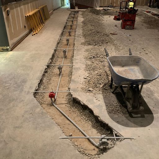 A wheelbarrow is sitting in the middle of a construction site.