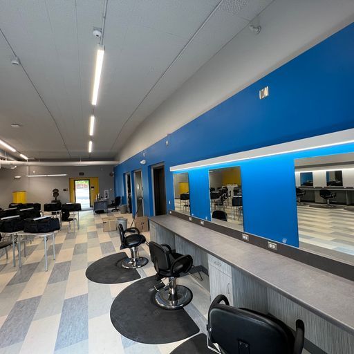 A hair salon with blue walls and black chairs