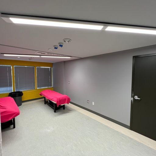 A room with two beds and a trash can in it