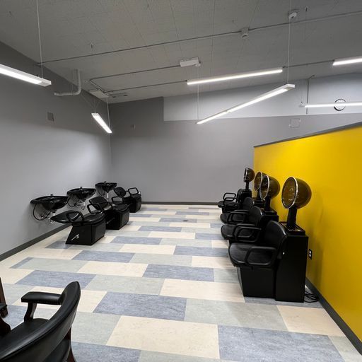 A room with a lot of hair dryers and chairs