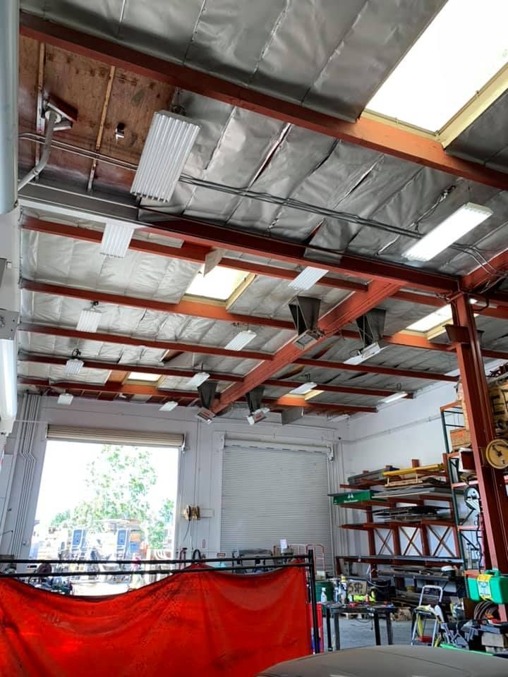 The inside of a garage with a lot of lights on the ceiling.