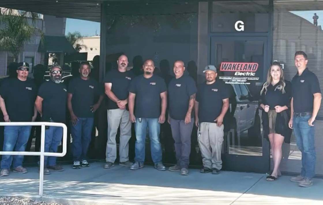 A group of people standing in front of a building with the letter g on it