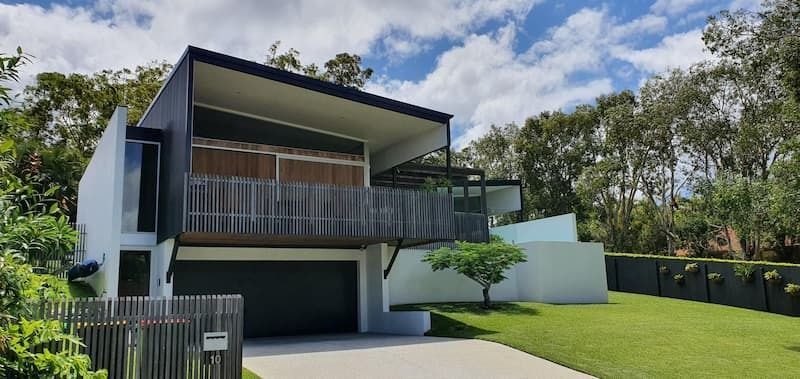 A Large White House with A Black Garage and A Balcony Surrounded by Trees — MJ Render in Buderim, QLD