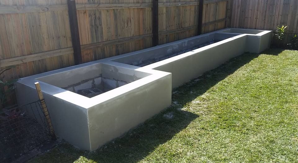 A Concrete Planter Is Sitting in The Grass Next to A Wooden Fence — MJ Render in Buderim, QLD