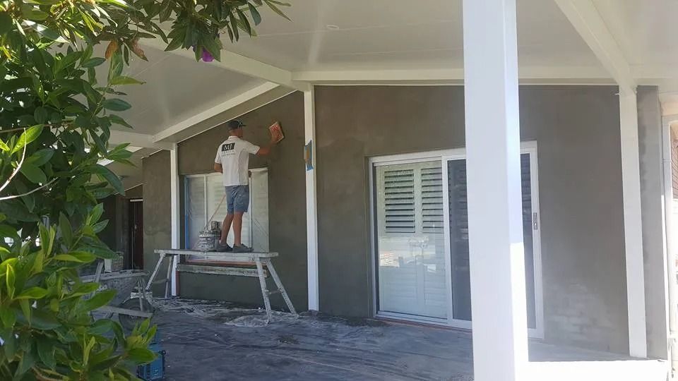 A Man Is Standing on A Scaffolding Painting the Side of A House — MJ Render in Buderim, QLD
