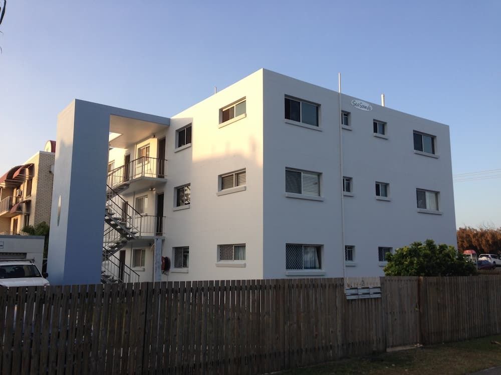 A White Building with A Wooden Fence in Front of It — MJ Render in Buderim, QLD