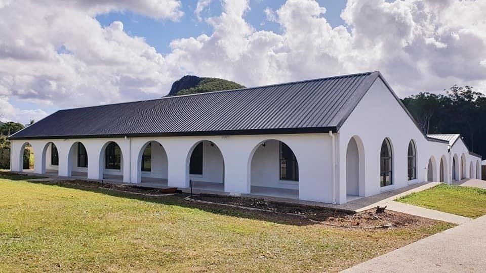 A Large White Building with Arches and A Black Roof — MJ Render in Buderim, QLD