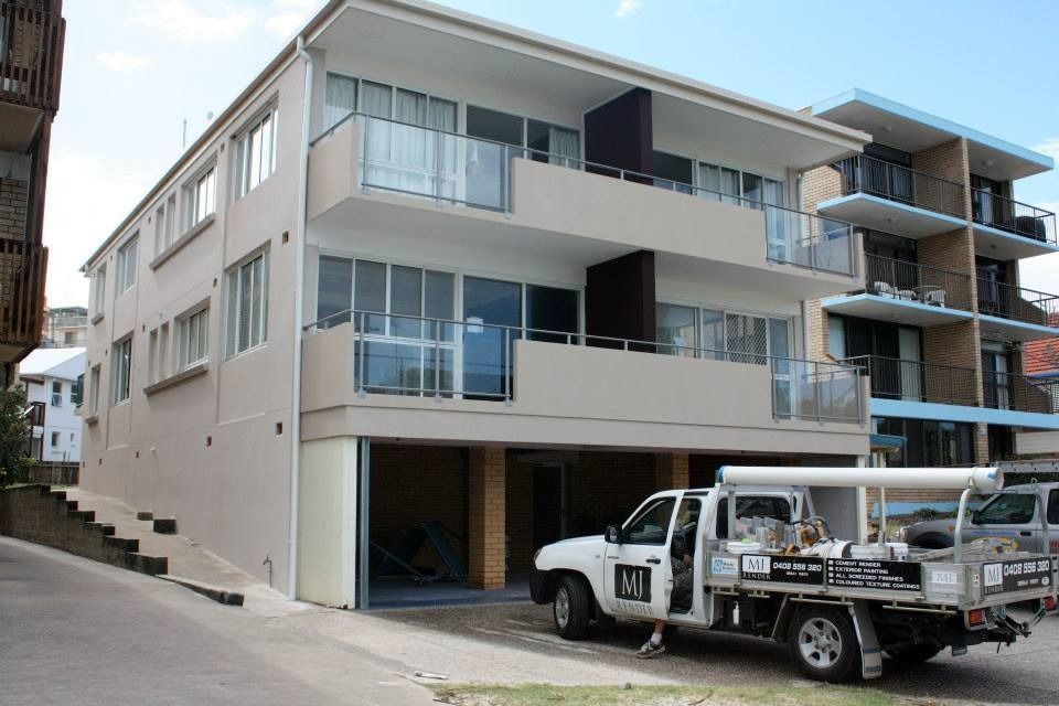 A White Truck Is Parked in Front of A Large Apartment Building — MJ Render in Buderim, QLD