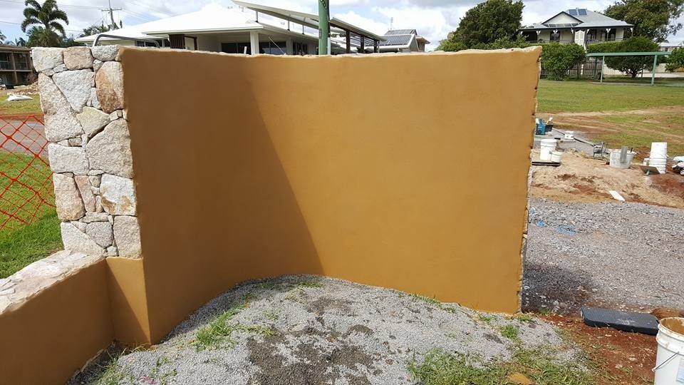 A Large Brown Wall Is Sitting on Top of A Pile of Gravel in Front of A House — MJ Render in Buderim, QLD