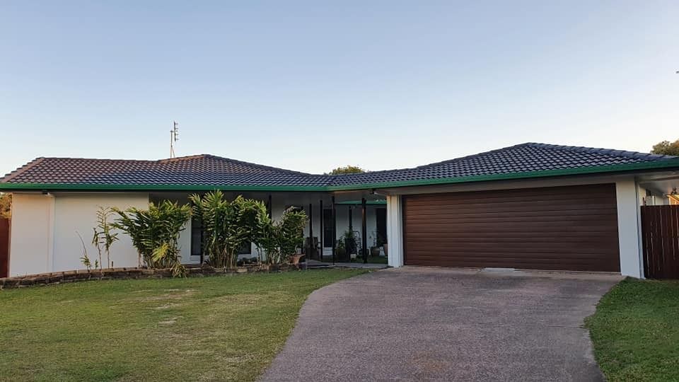 A Large White House with A Brown Garage Door and A Green Roof — MJ Render in Buderim, QLD