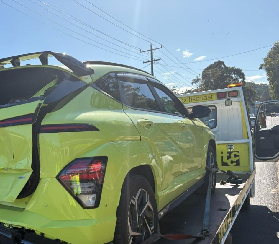 A Yellow Til Towing truck park in carrying a yellow car