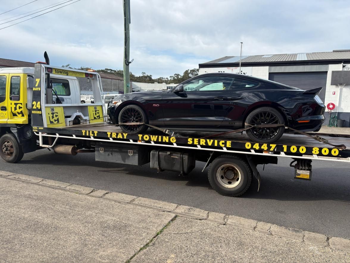 A Yellow Til Towing truck park in carrying a spa