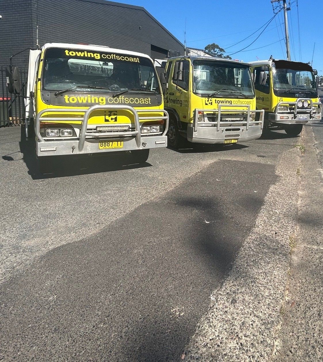 a set of yellow tow trucks next to each other — TCC Towing Coffs Coast in Harbour, NSW