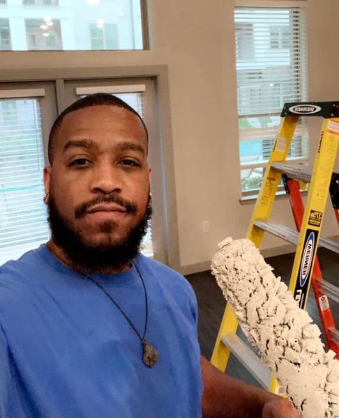 A Man Is Painting A Wall With A Paint Roller - Spring, TX - DJ's Painting A Man Is Painting A Wall With A Paint Roller - Spring, TX - DJ's Painting