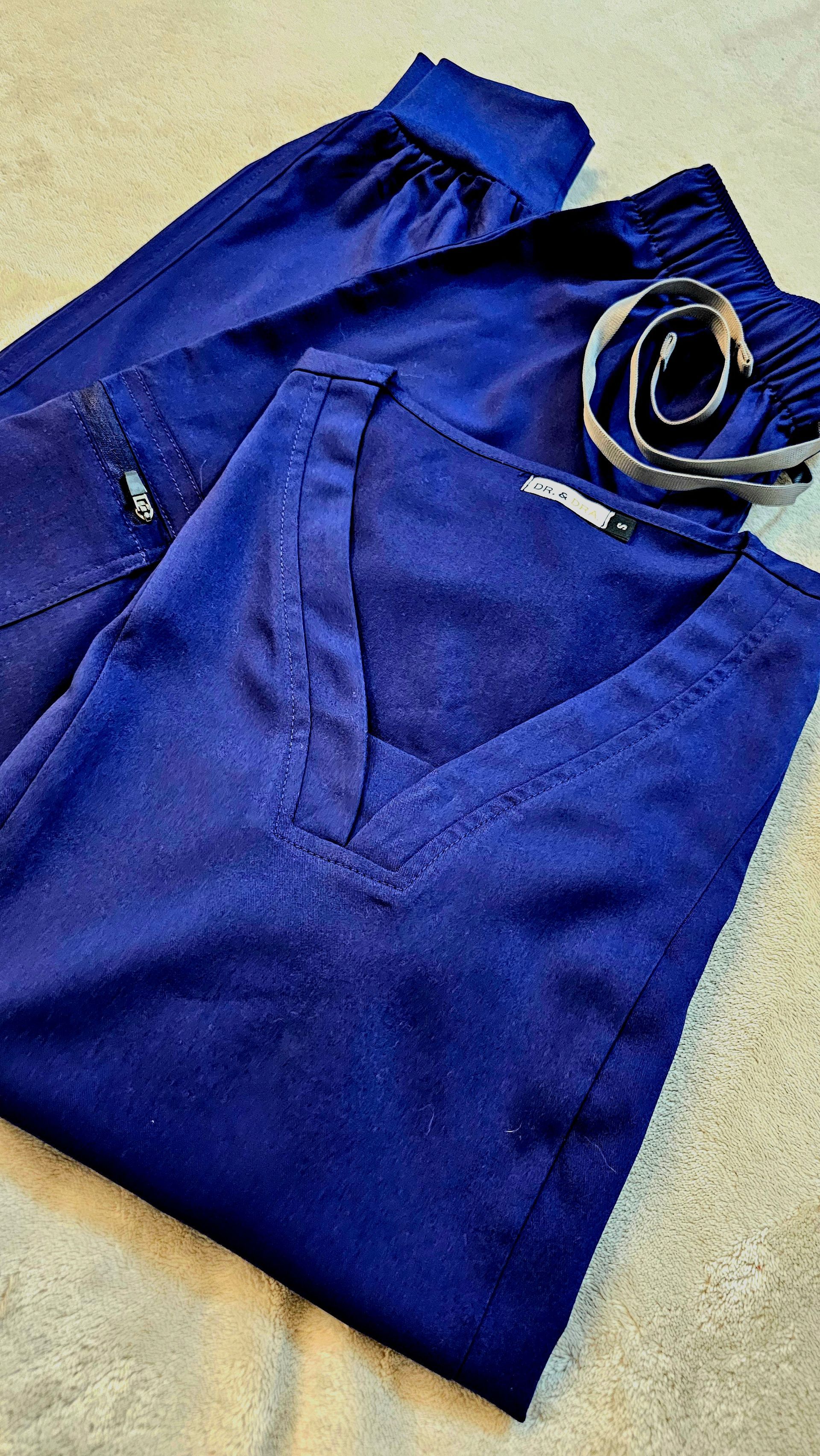 Tres mujeres con uniformes y cofias de la marina de pie en el pasillo de un hospital, sonriendo a la cámara.