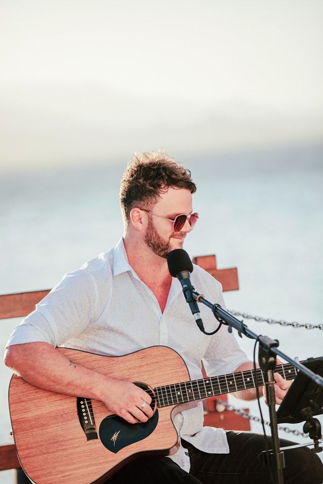 A man is playing a guitar and singing into a microphone.