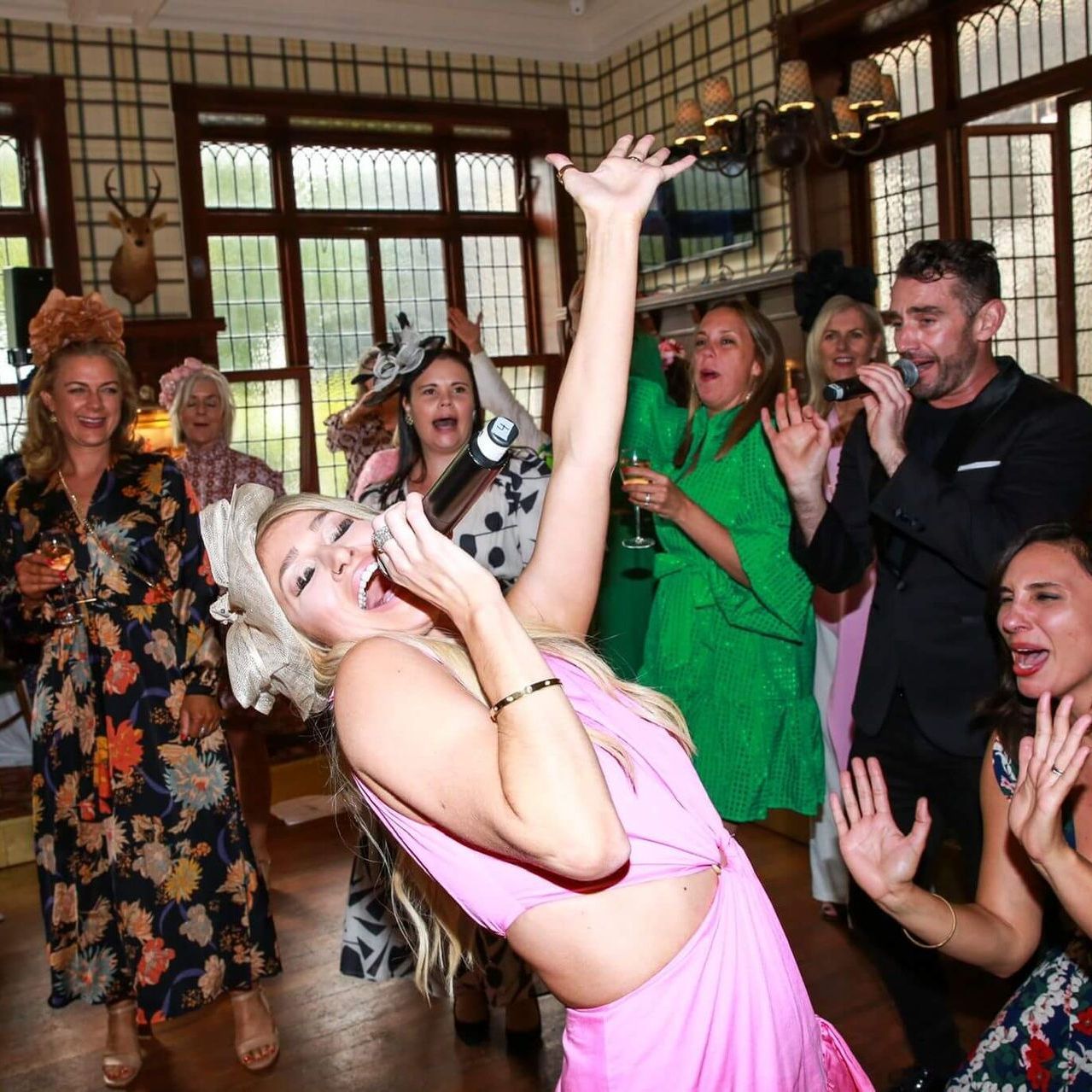A woman in a pink dress is dancing with a group of people