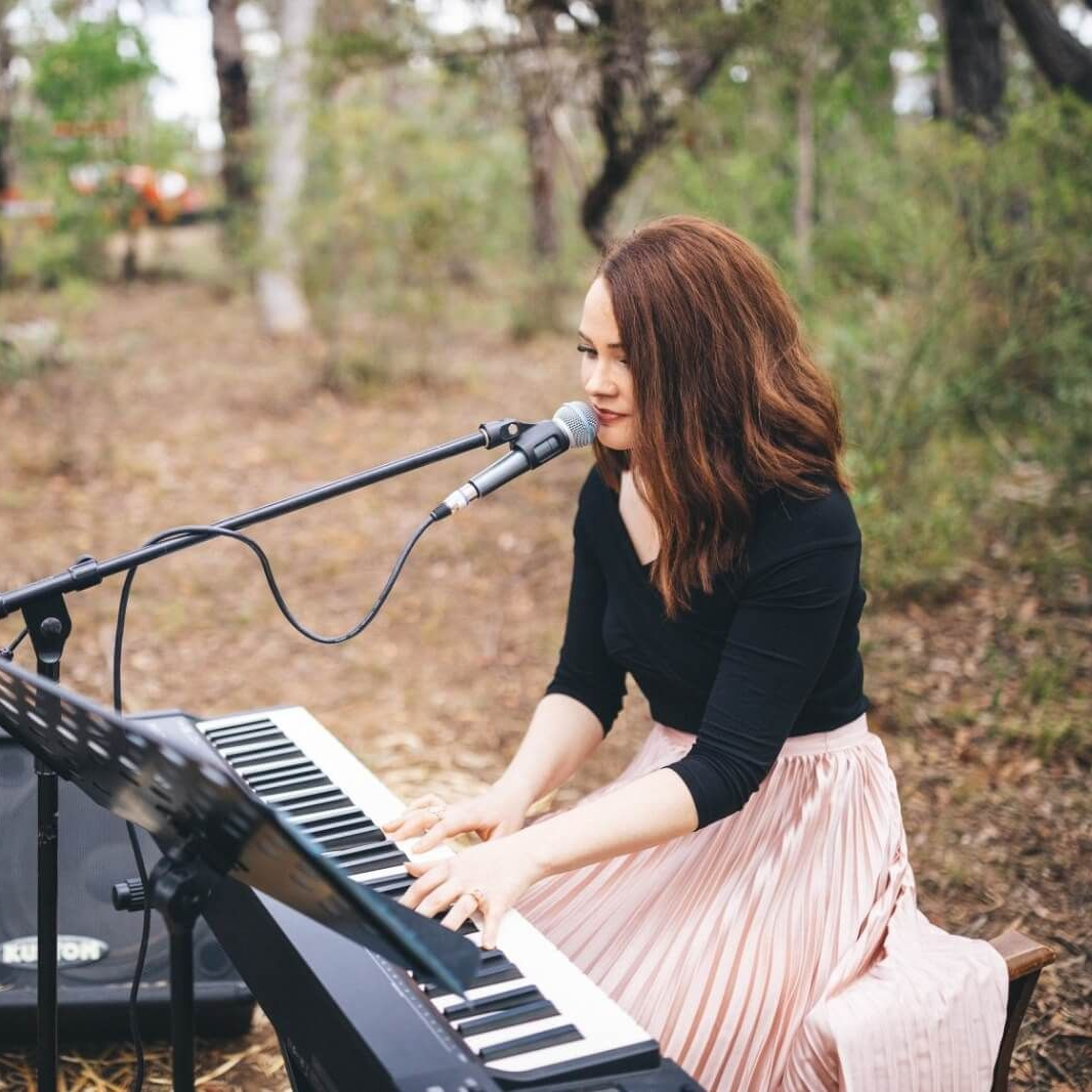 Sarah singing and playing piano for a wedding ceremony