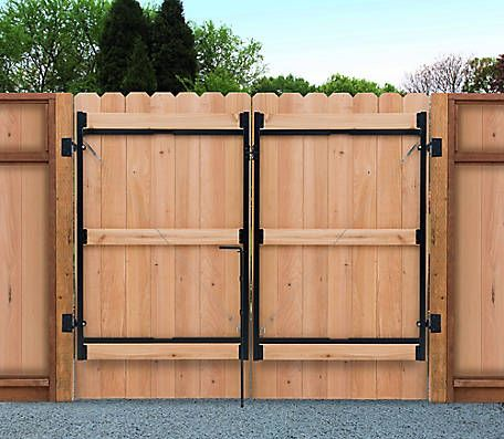 Wooden double gate, light brown, black metal hardware, set into a matching fence.