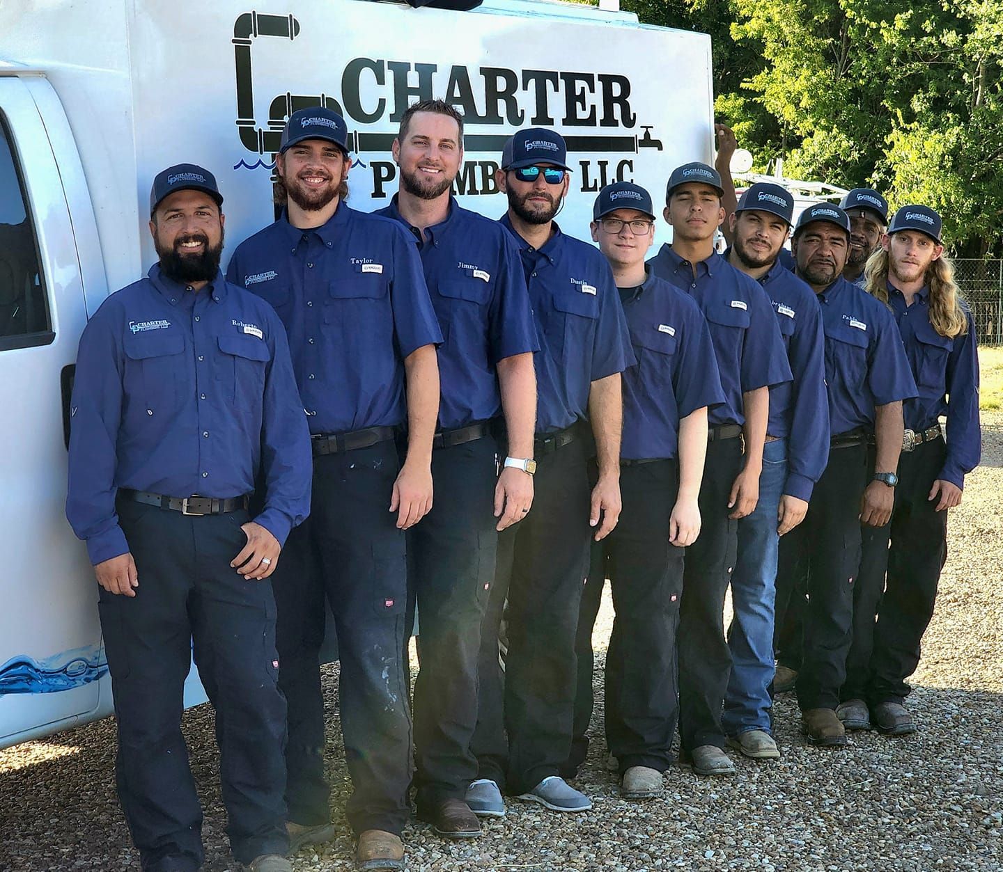 A group of men are posing for a picture in front of a charter van