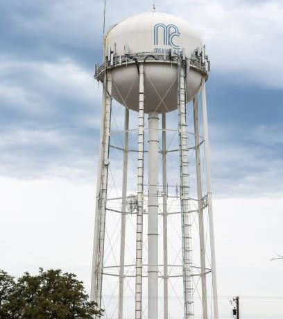 A large white water tower with the letters ne on it