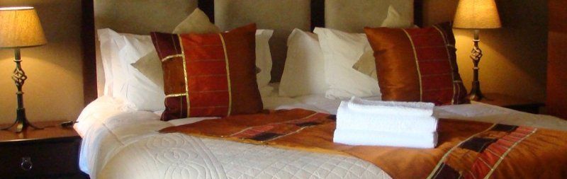 A hotel room with a bed , two lamps , and a towel on the bed.