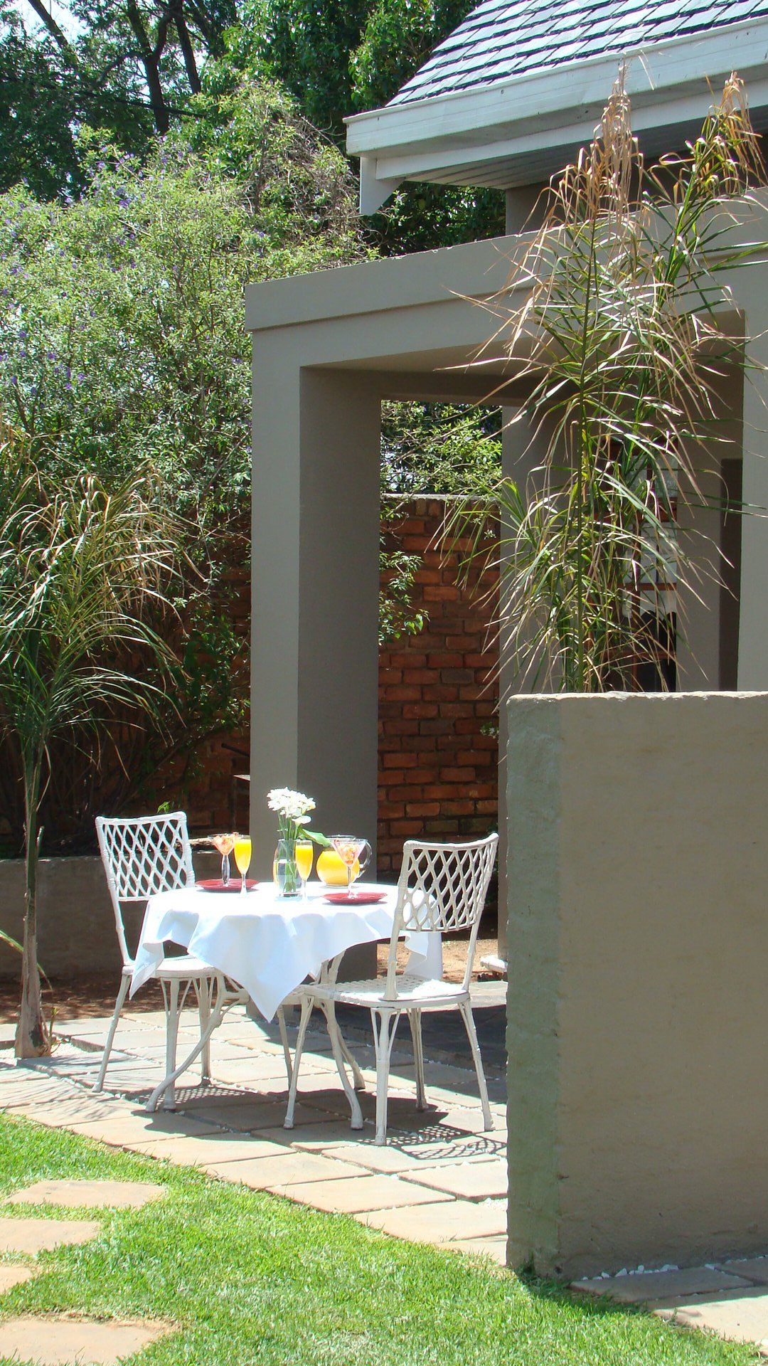A table and chairs are sitting outside of a house.