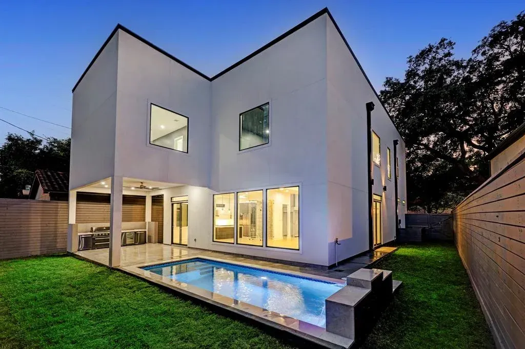 A white house with a swimming pool in the backyard