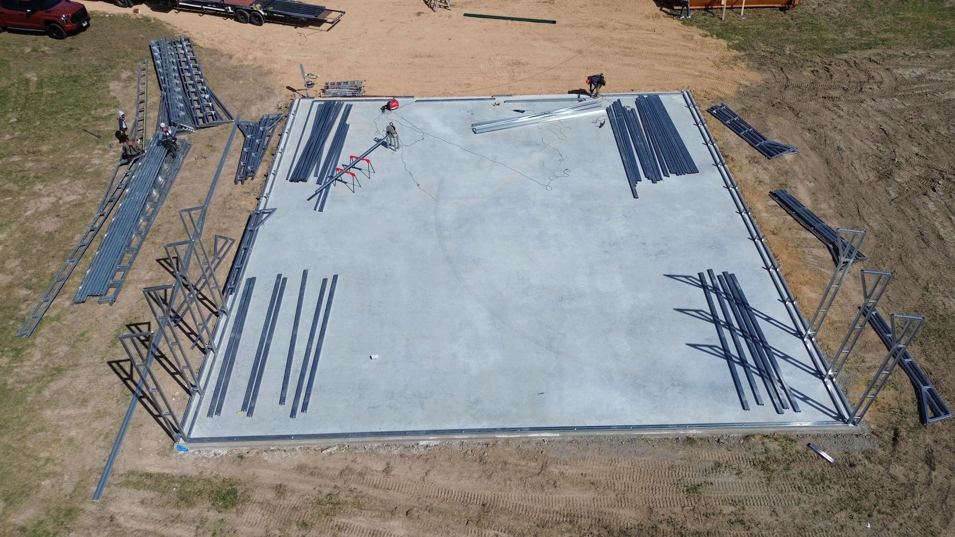 An aerial view of a concrete foundation being built in a field.