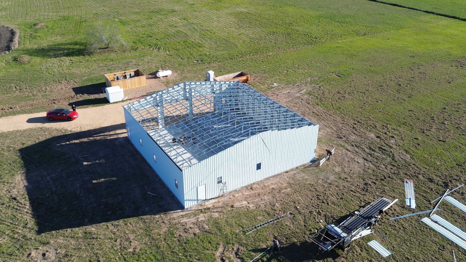 An aerial view of a building under construction in a field.
