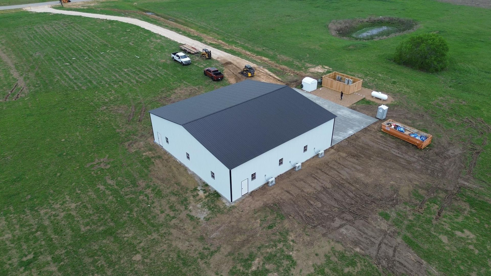 An aerial view of a barn being built in a field.