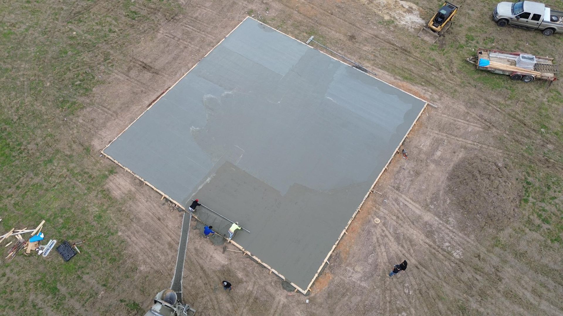 An aerial view of a concrete foundation being built in a field.