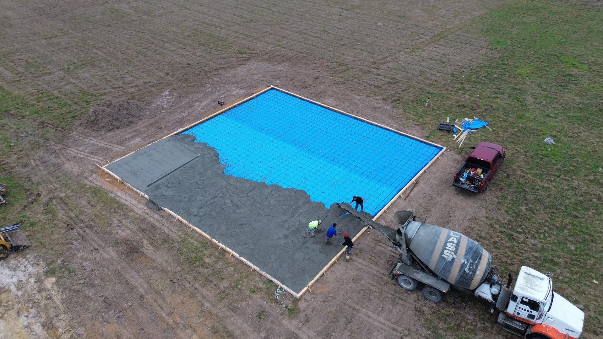 An aerial view of a swimming pool being built in a field.