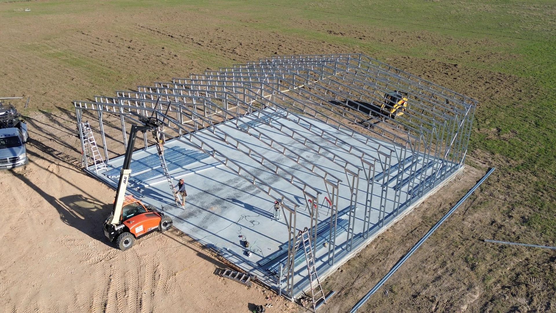 An aerial view of a building under construction in a field.