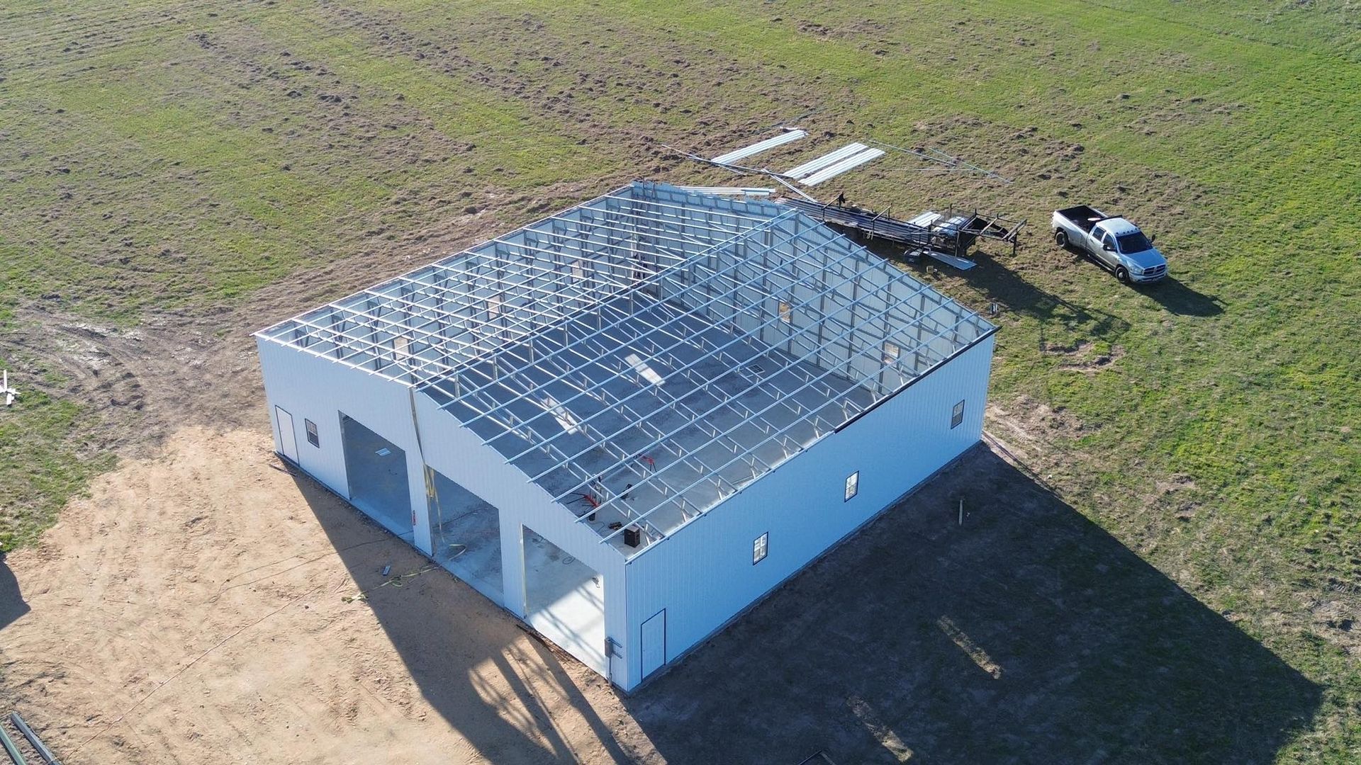 An aerial view of a building under construction in a field.