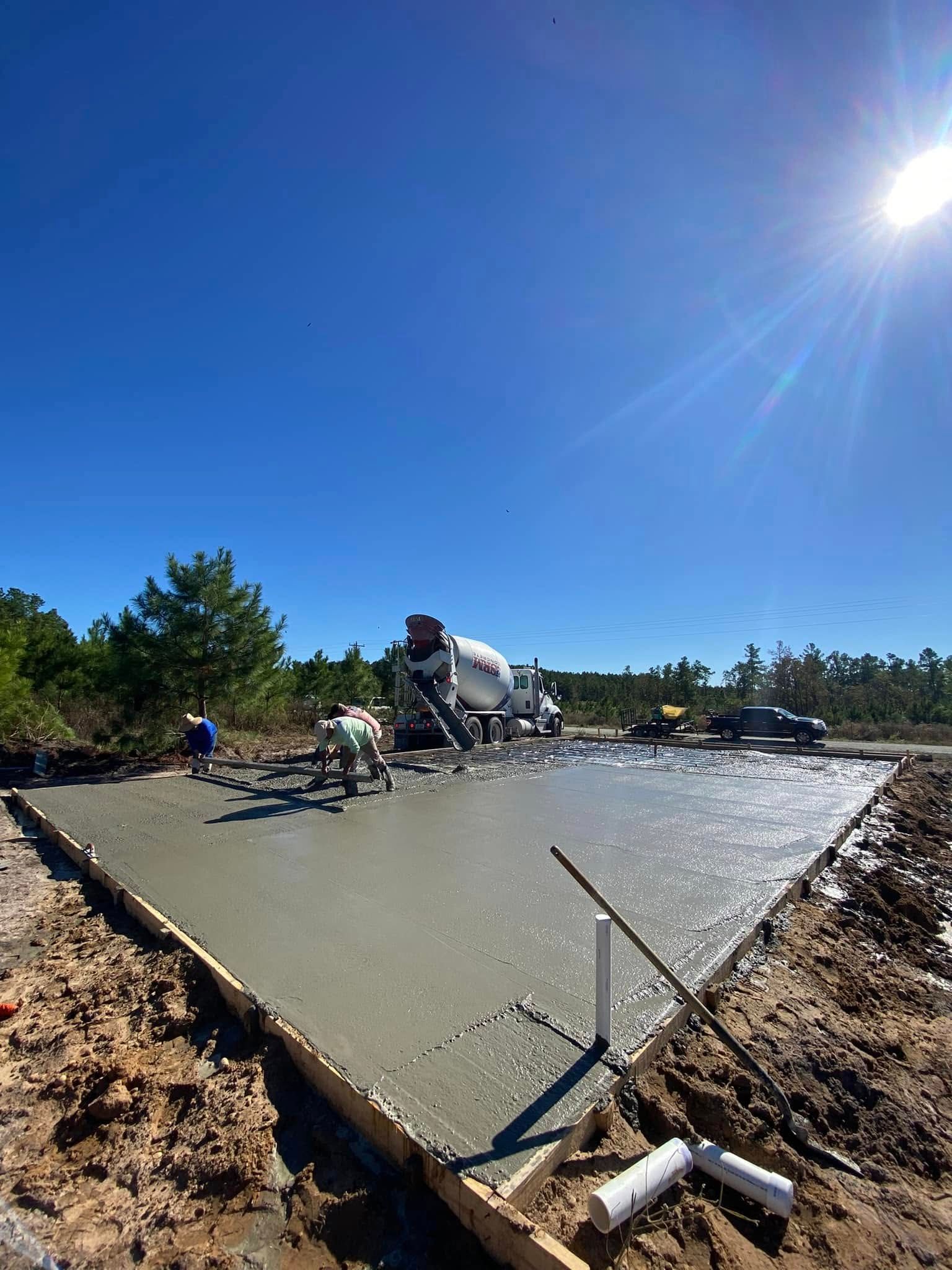 A concrete slab is being poured on a construction site.
