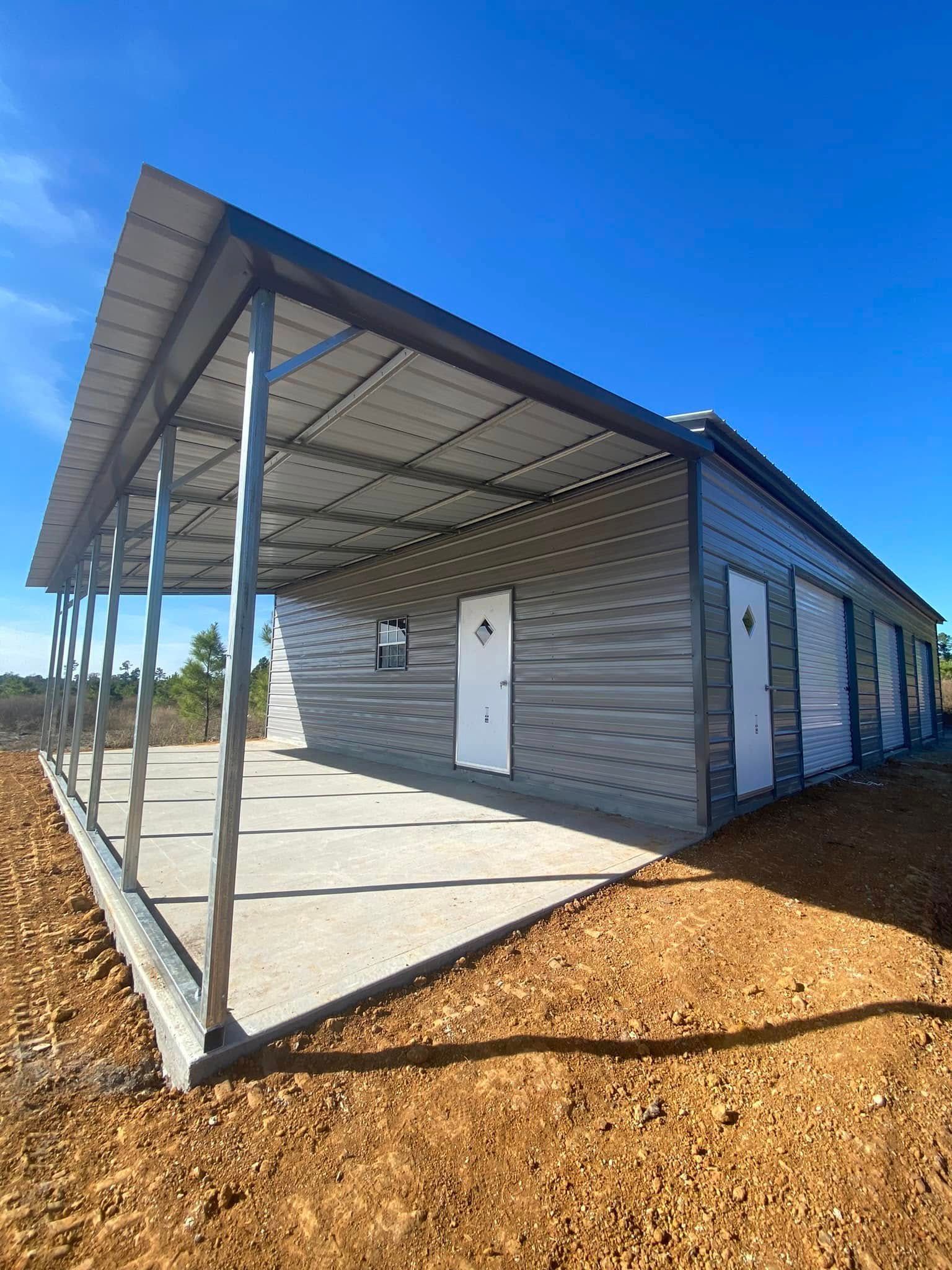 A large metal building with a porch and a blue sky in the background.